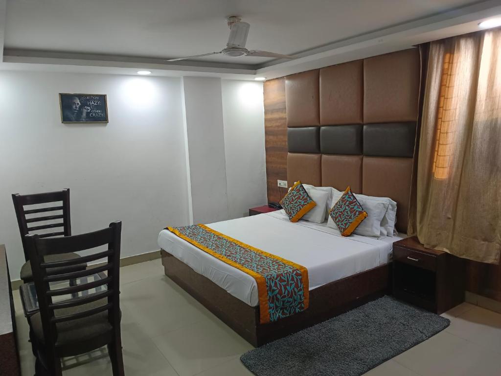1 dormitorio con 1 cama grande y 1 silla en Hotel Aerotech Suite en Nueva Delhi