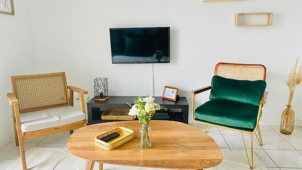 a living room with a table and a tv at Porte de Saint Emilion in Coutras