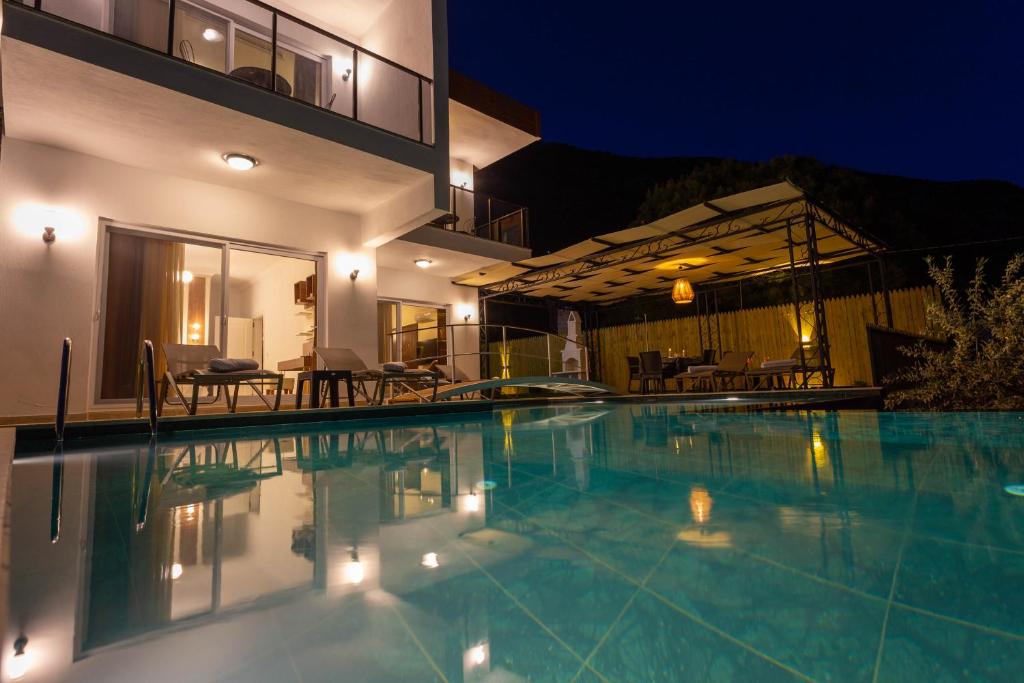 a swimming pool in front of a house at night at Villa Marine Luxury in Kas