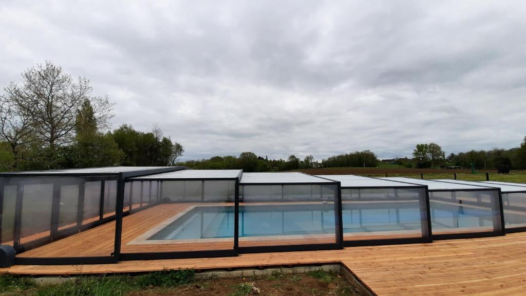 une maison avec une piscine aux parois en verre dans l'établissement Le Hameau du Pagnon, à Saint-Mesmin