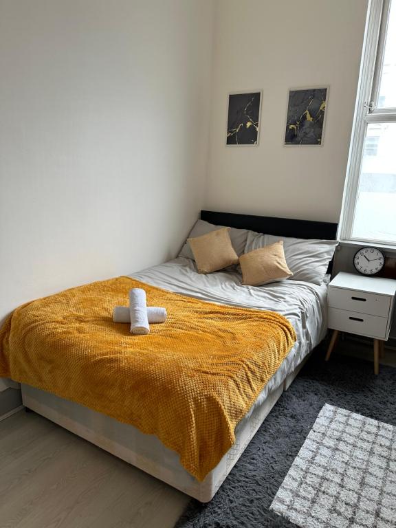sypialnia z łóżkiem z żółtym kocem w obiekcie Superb Modern Flat in Kings Cross w Londynie