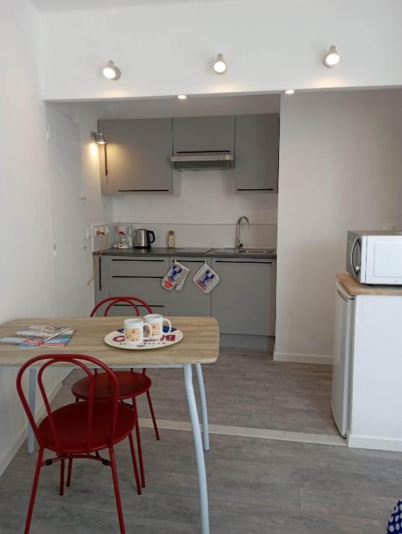 une cuisine avec une table, deux chaises et un comptoir dans l'établissement Le Krogen, à Locmiquélic