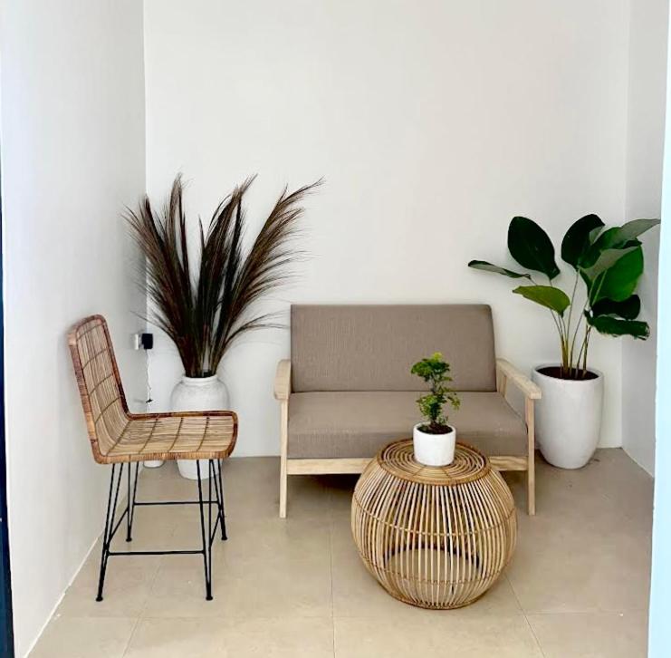 a room with a chair and a couch and plants at NEW Modern Suite near Airport & Beach in Sudtungan
