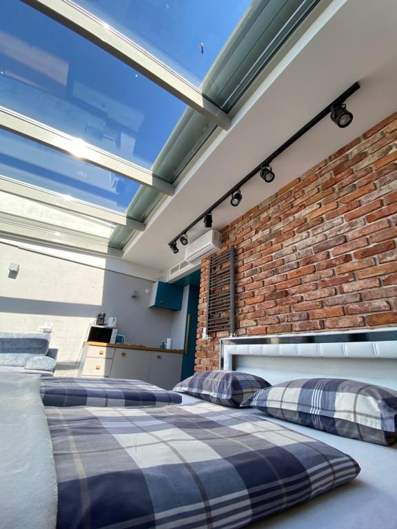 2 camas en una habitación con una pared de ladrillo en TOP VIEW SKY & SEA- Maloves Apartament z widokiem na morze, en Władysławowo
