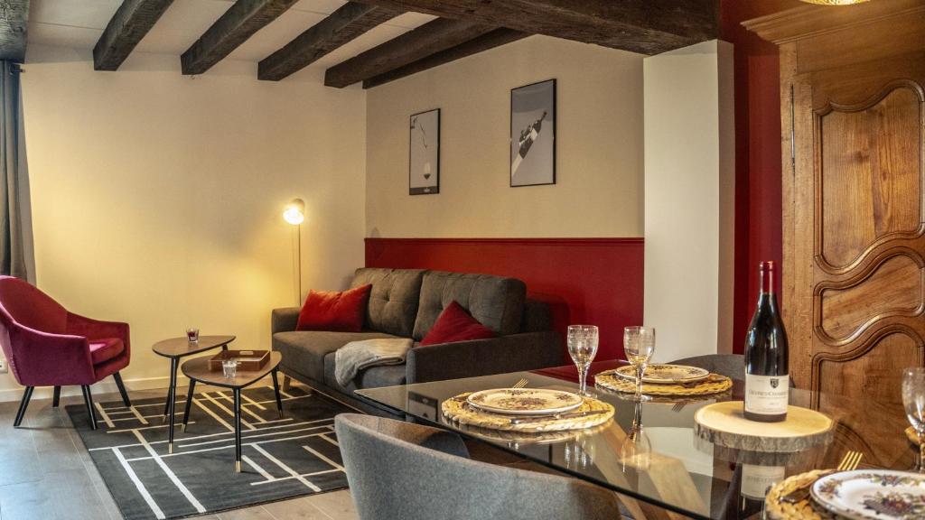 een woonkamer met een bank en een tafel met wijnglazen bij Le Sommelier Chalon in Chalon-sur-Saône