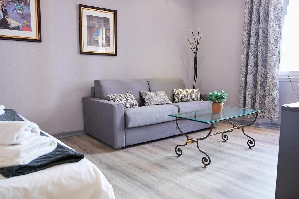 un salon avec un canapé et une table en verre dans l'établissement Suite Notre Dame - Appartements, à Cannes