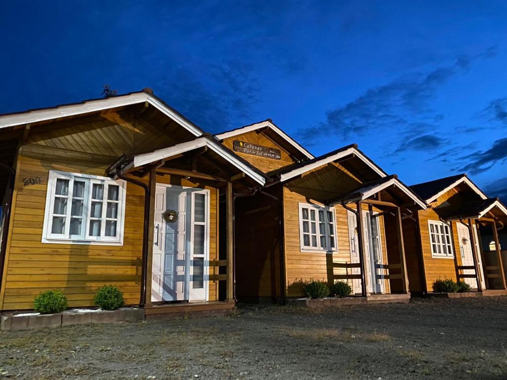 une maison en bois avec des fenêtres blanches dans l'établissement Cabanas Por do Sol, à Urubici