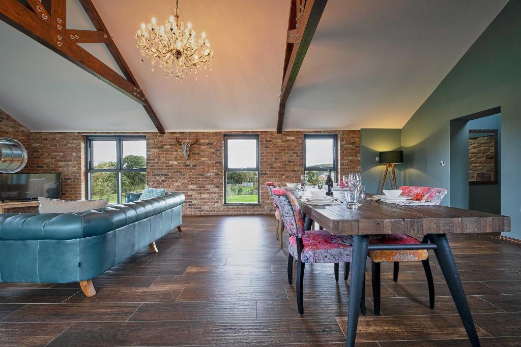 a dining room with a table and a couch at Woodland Barn in Durham