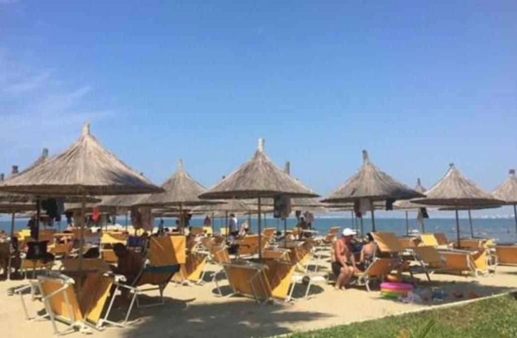 een stel stoelen en parasols op een strand bij Ferienwohnung Golem (Durres) in Golem