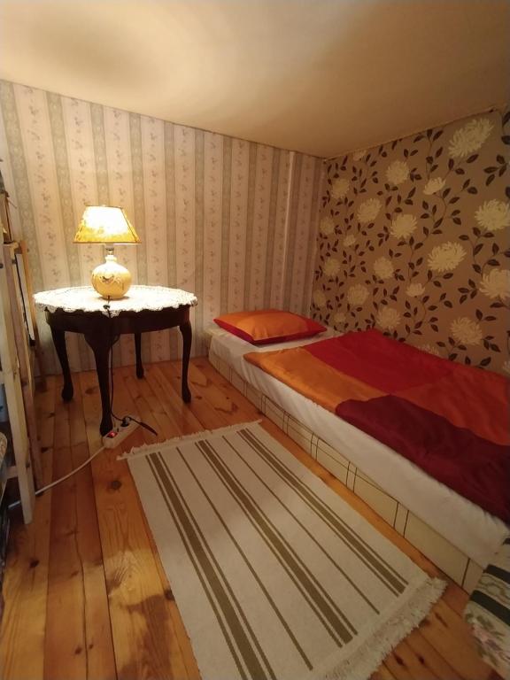 a bedroom with two beds and a table with a lamp at Cuki Apartment in Budapest