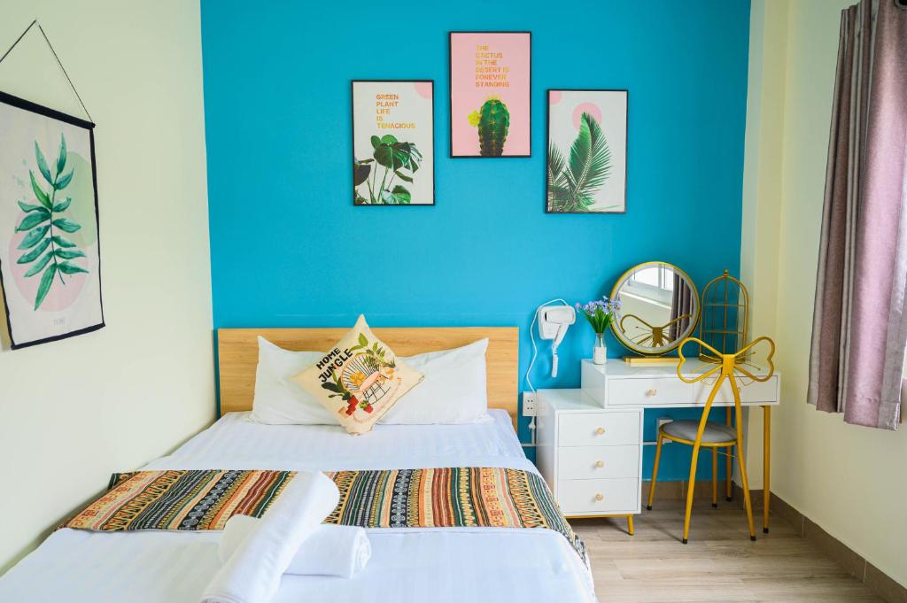 1 dormitorio con cama y pared azul en Jasmine Hotel, en Ho Chi Minh