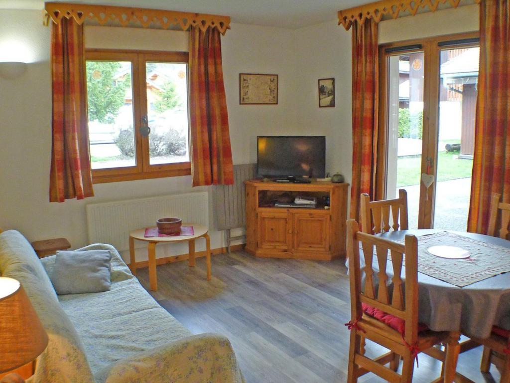 un salon avec un canapé, une télévision et une table dans l'établissement Appartement cosy avec piscines, parking et WiFi à Samoëns - FR-1-629-32, à Samoëns