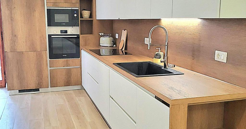 una cucina con lavandino e piano di lavoro di Bright and Large Apartment Via Montegrappa a Livorno