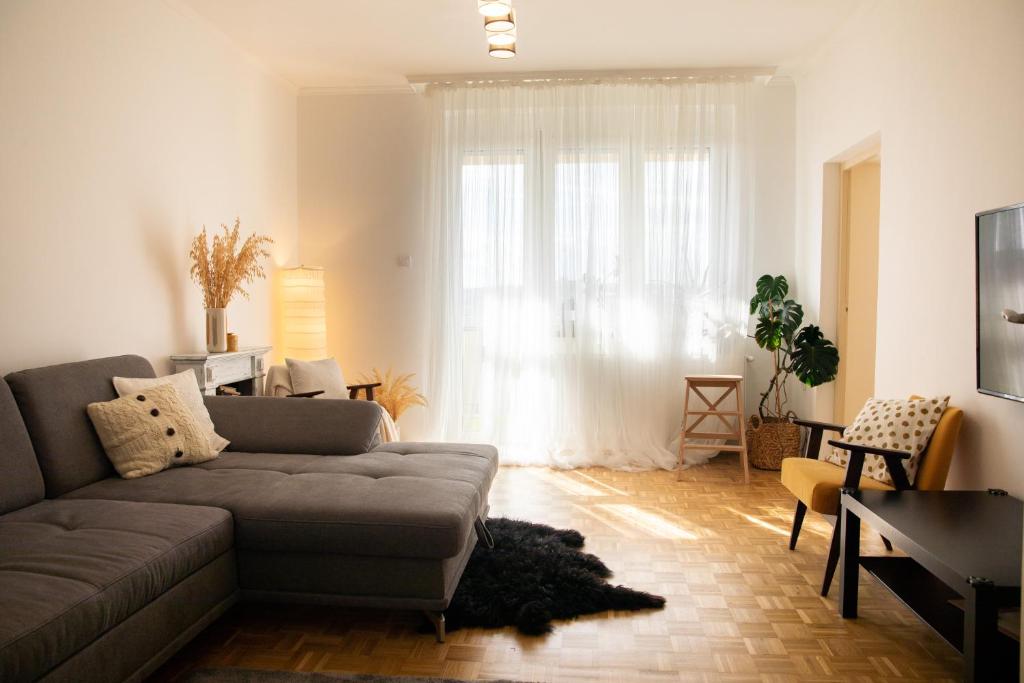 uma sala de estar com um sofá e uma janela em Firpo Apartman em Eger
