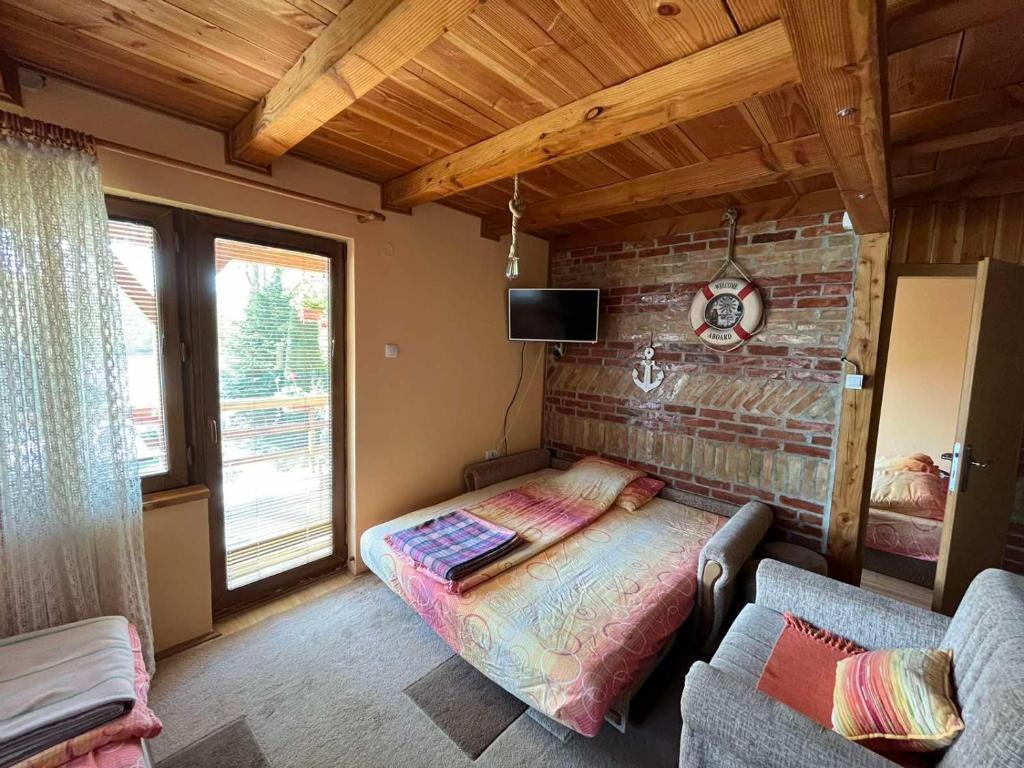 Ljubovija的住宿－Apartman "Kapetana luka"，一间卧室设有一张床和砖墙