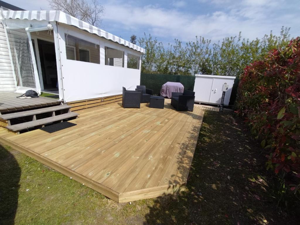 a wooden deck in front of a house at Mobil home Vendée in Saint-Jean-de-Monts