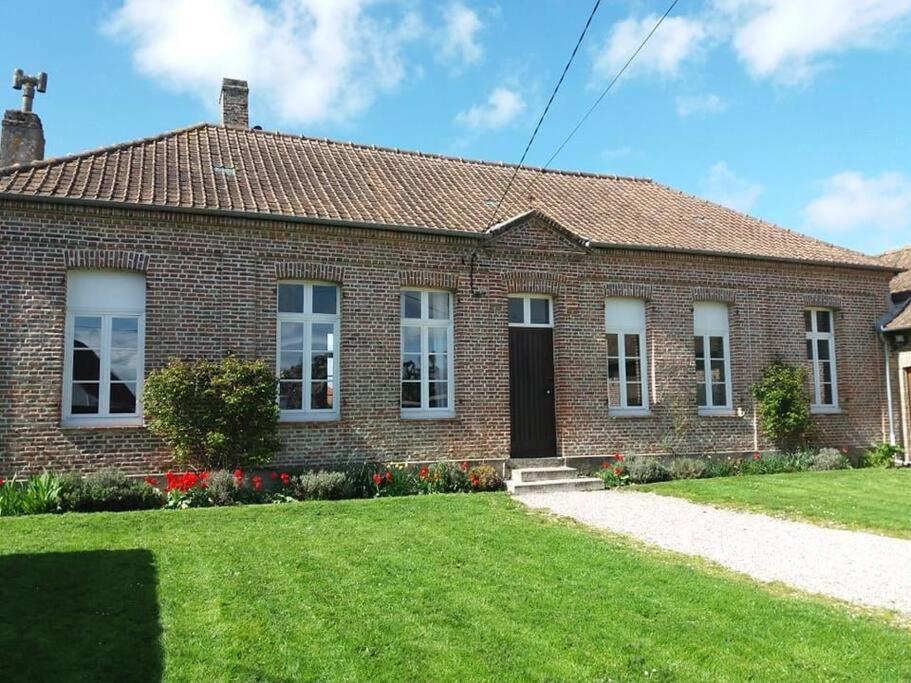 a brick house with a green lawn in front of it at Le Presbytère de la côte d'opale in Nempont-Saint-Firmin