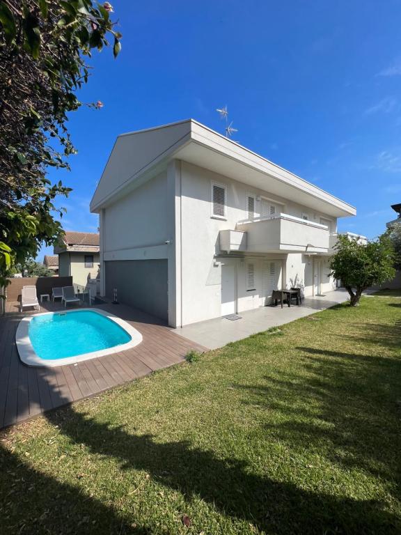 una casa con piscina frente a ella en WHITE HOUSE, en Aci Catena