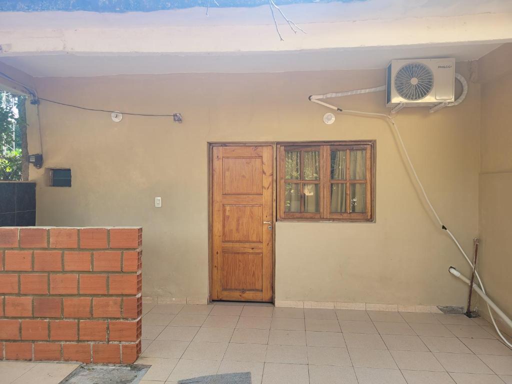 um quarto com uma porta e uma ventoinha na parede em Lautaro alojamiento em Posadas