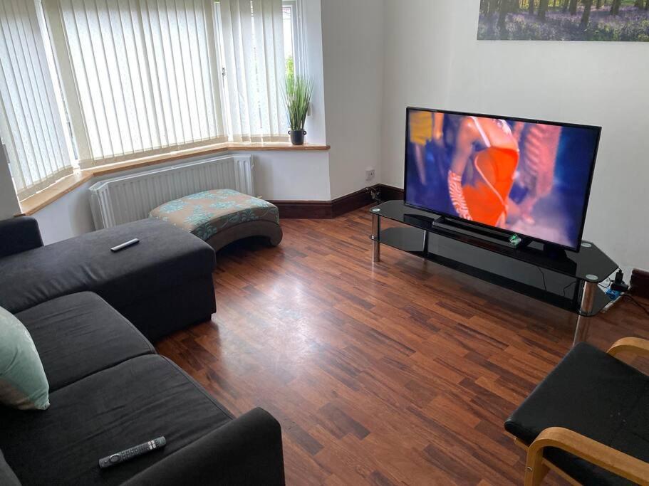 a living room with a couch and a flat screen tv at Amazing 4 bed Contractor hub in Nuneaton