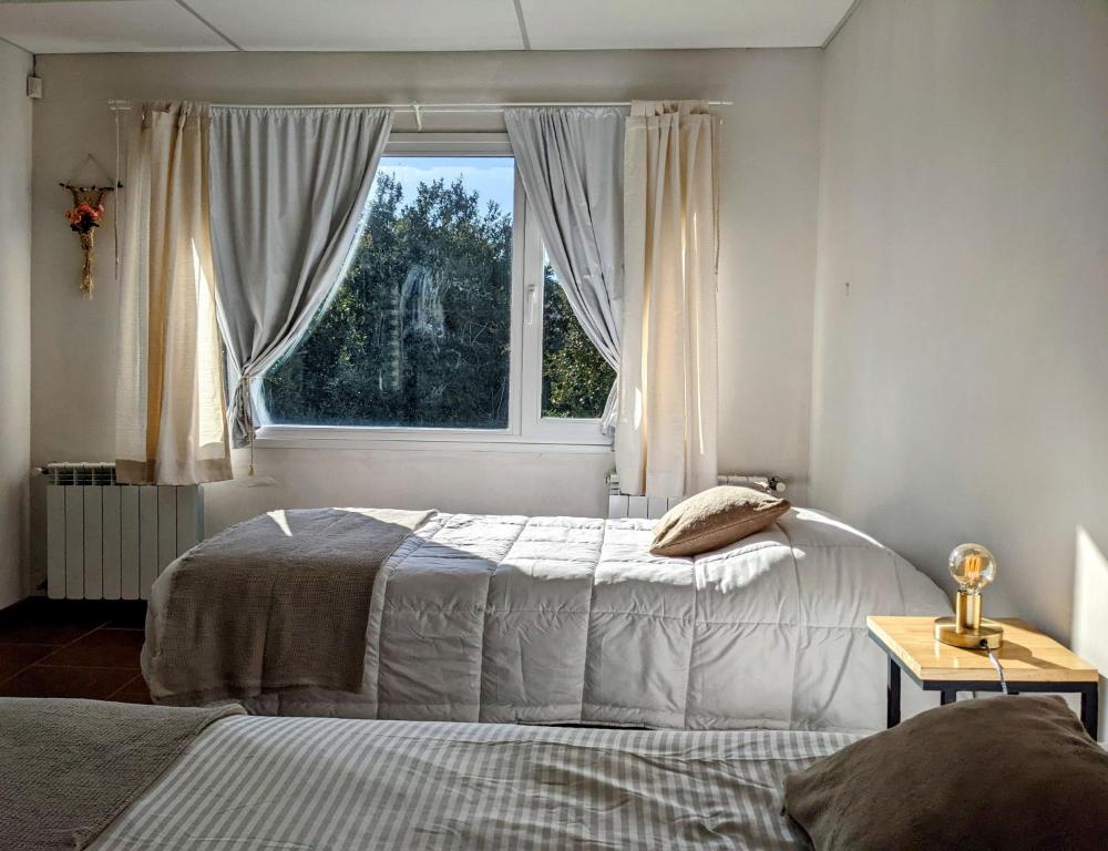 a bedroom with two beds and a window at Casa del Sur in San Carlos de Bariloche