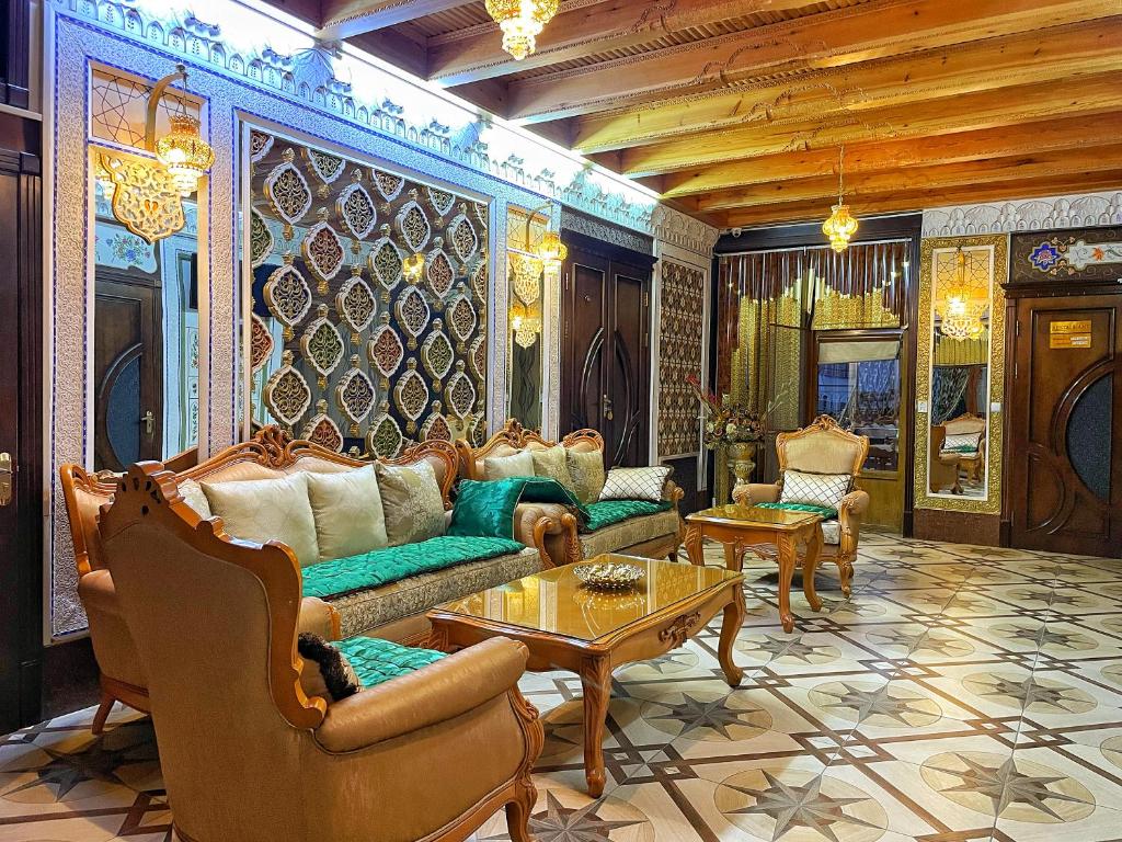 a living room with a couch and chairs and a table at Hotel Nurafshon Boutique in Bukhara
