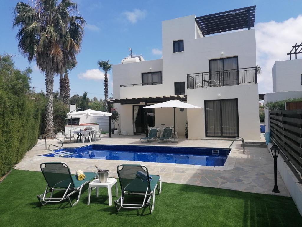 - une vue sur une maison avec une piscine dans l'établissement Villa Med-Sunset, à Kissonerga