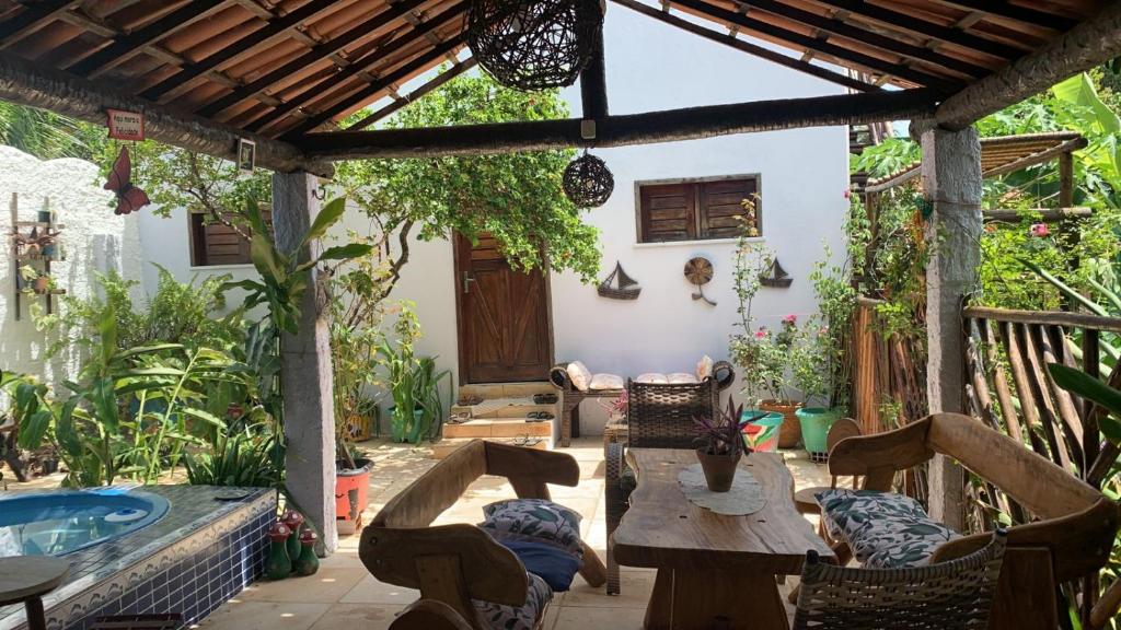 a patio with a table and chairs and a pool at Pousada da Lucinha in Canoa Quebrada