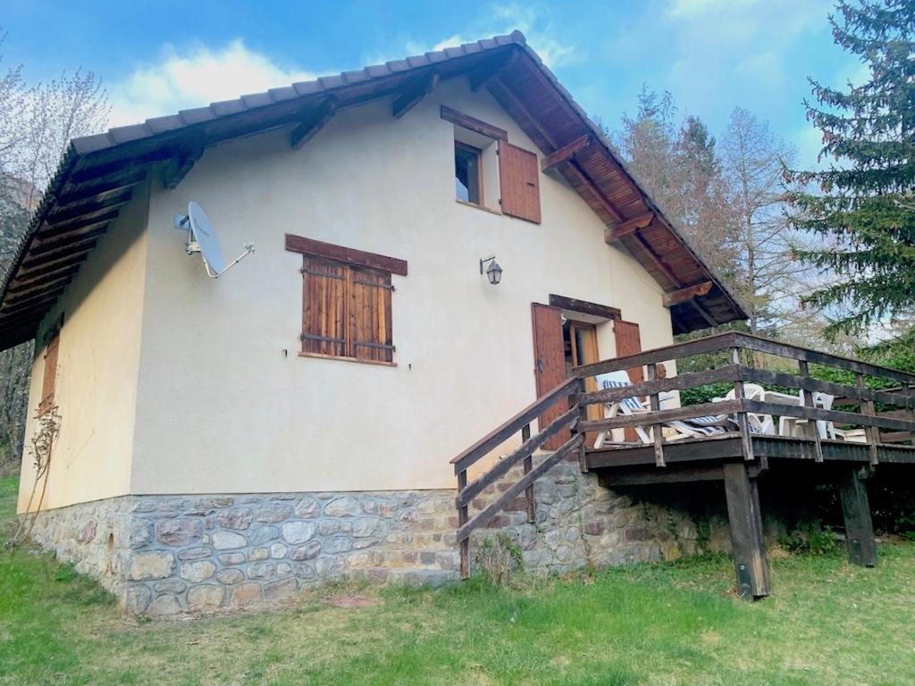 a house with a porch and a wooden deck at Chalet douillet tout confort in Valdeblore