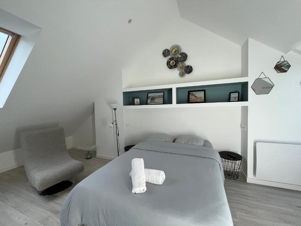 1 dormitorio blanco con 1 cama y 1 silla en Onyx d'Opale, en Calais