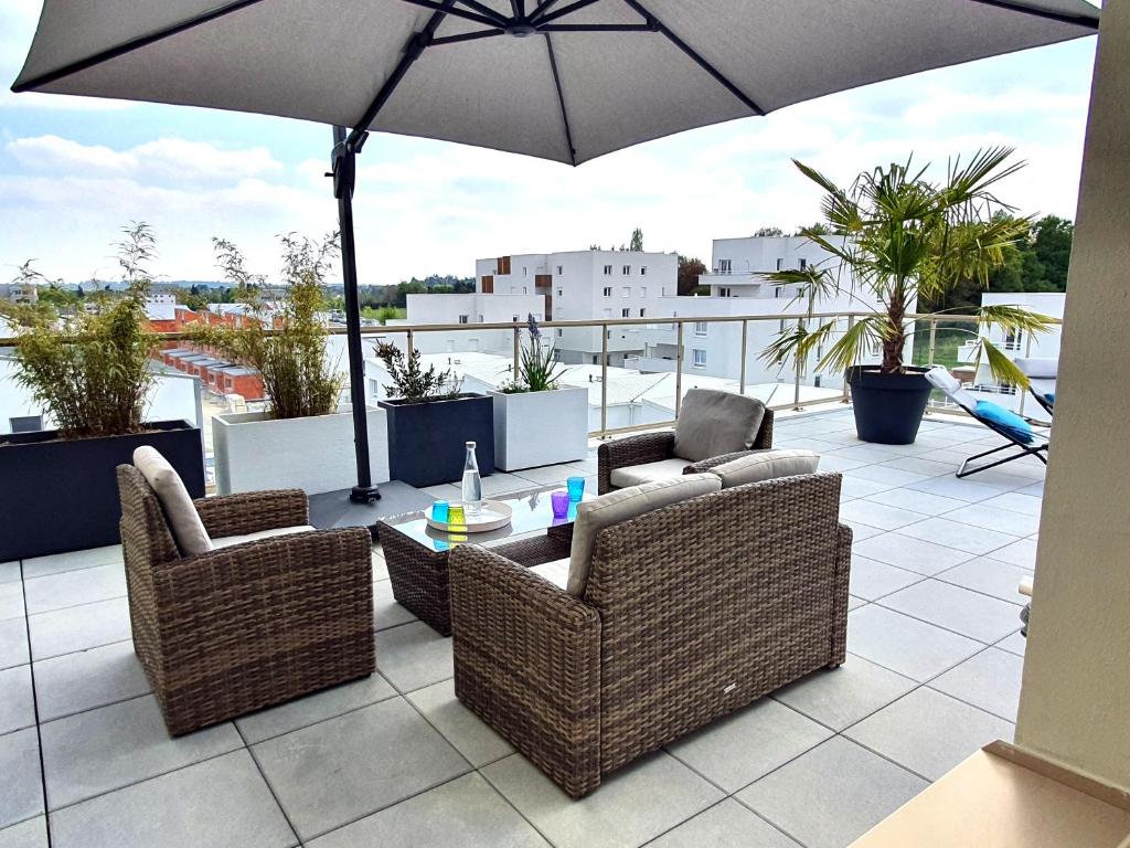 un patio avec des chaises, une table et un parasol dans l'établissement ViaSilvaDoma : Metro, Parking, Terrasse, à Cesson-Sévigné