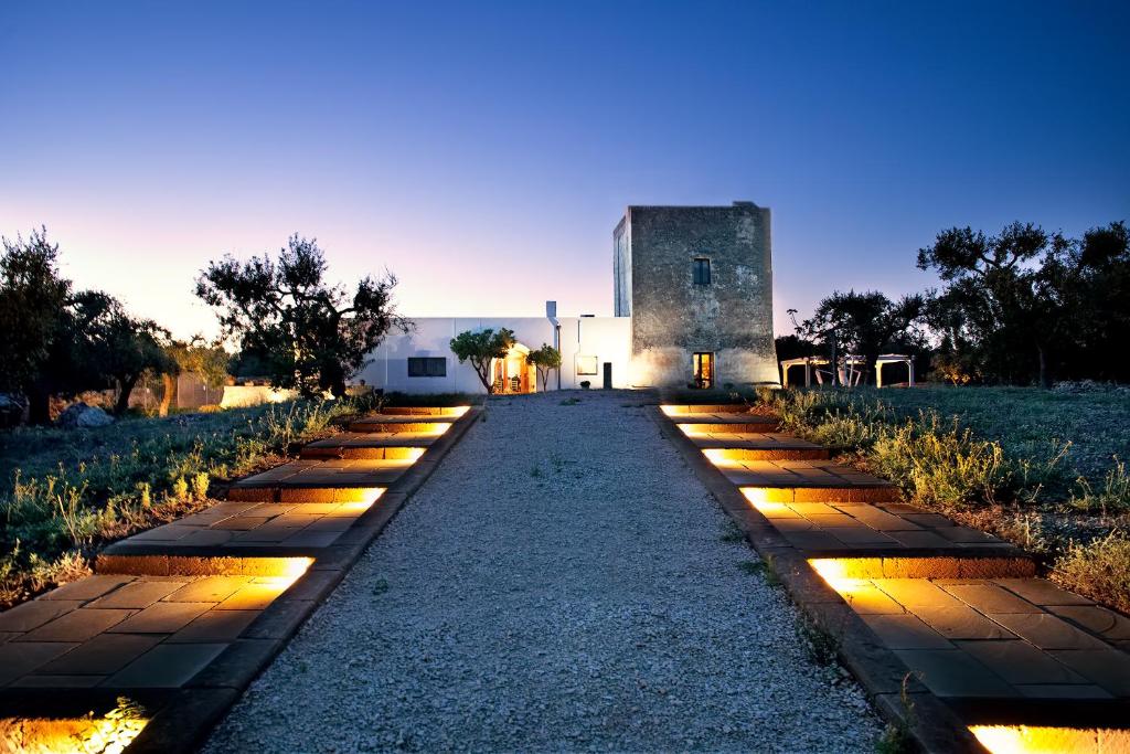 a pathway with lights in front of a building at Agriturismo Torre del Cardo in Torre Lapillo