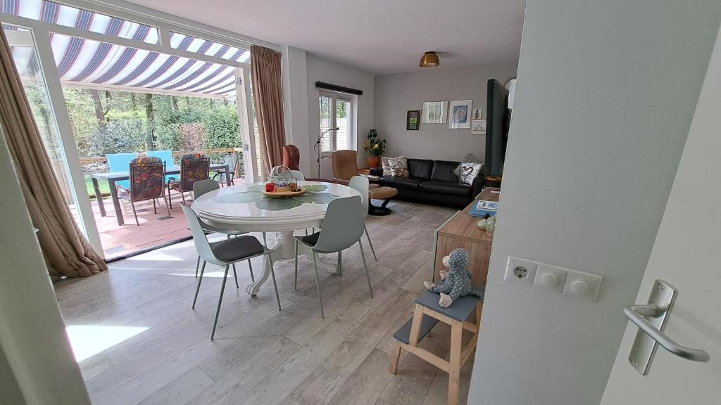 een keuken en een woonkamer met een tafel en stoelen bij 't Grieze Huysje in Otterlo