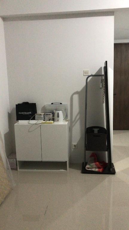a room with a desk and a stand with a printer at Citisquare apartment for good sleeper in Tenggilismedjojo