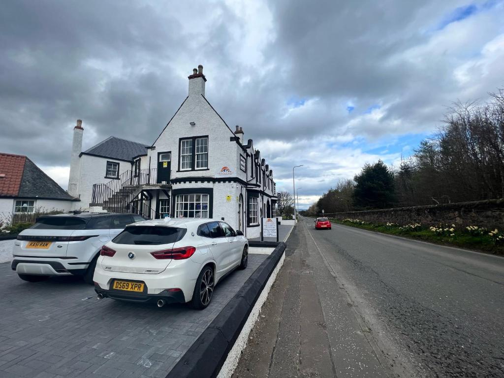 a white car parked in front of a house at Earl David Hotel in East Wemyss