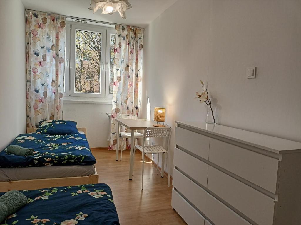1 dormitorio con cama, escritorio y ventana en Lemuria Jawor pokoje, en Jawor