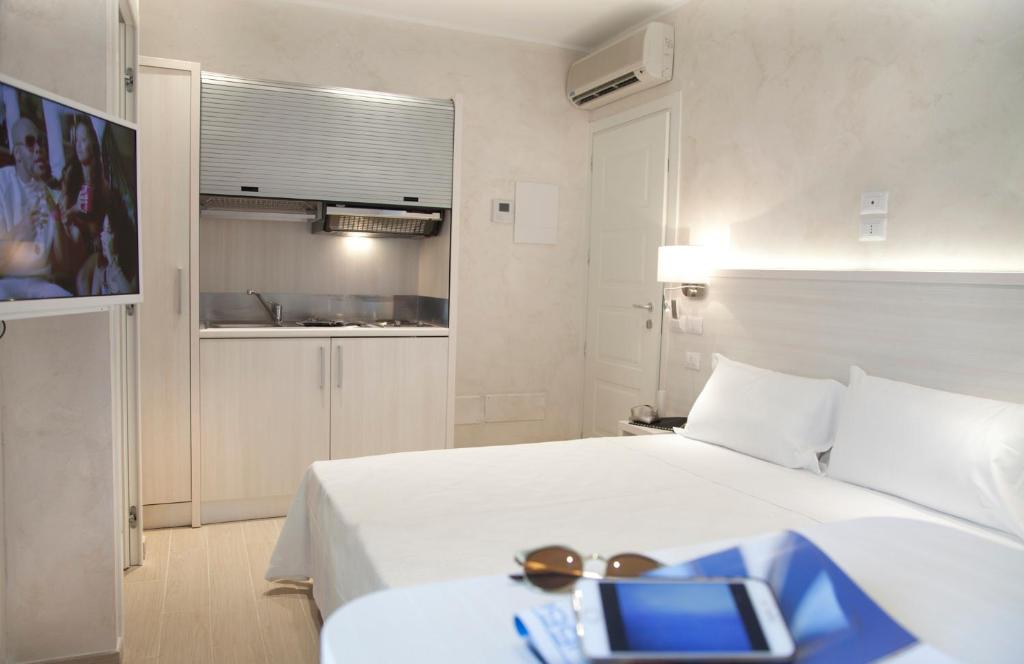 リミニにあるHotel Residence Maria Graziaのベッドルーム1室(タブレット付きのベッド1台付)