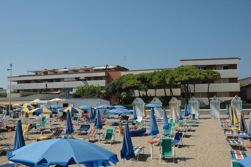 un mucchio di sedie e ombrelloni su una spiaggia di Residenza Casa Mare a Lignano Sabbiadoro