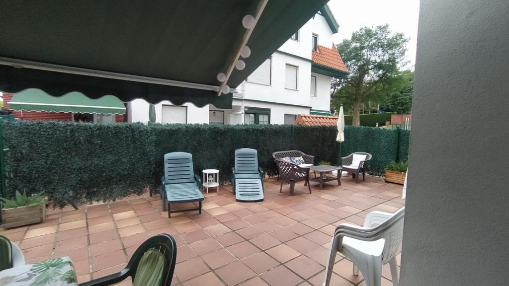 a patio with chairs and tables and a fence at El naranjo in Gama