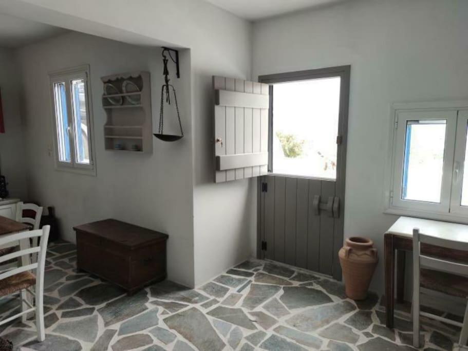 ein Wohnzimmer mit einem Tisch und einem Fenster in der Unterkunft Anna's Cottage Home in Galini