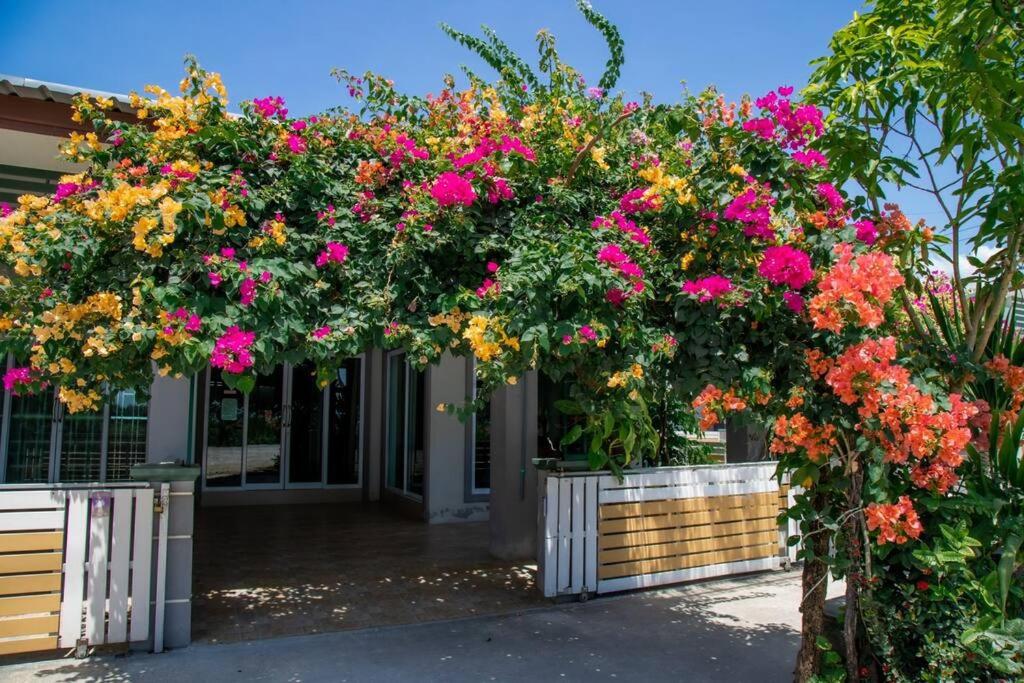 a garden with pink and yellow flowers on a building at Sichon Holidays in Sichon