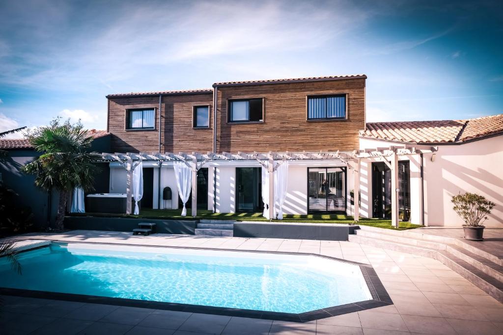 a house with a swimming pool in front of a house at Suites by Aix Keys avec jacuzzi privatif 5 min des plages Fouras in Saint-Laurent-de-la-Prée