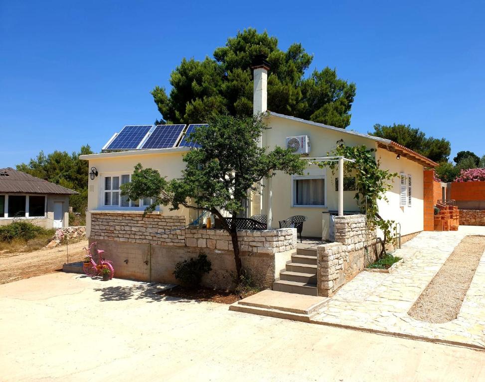 ein Haus mit Sonnenkollektoren darüber in der Unterkunft CAPTAIN'S Holiday HOUSE in Žirje