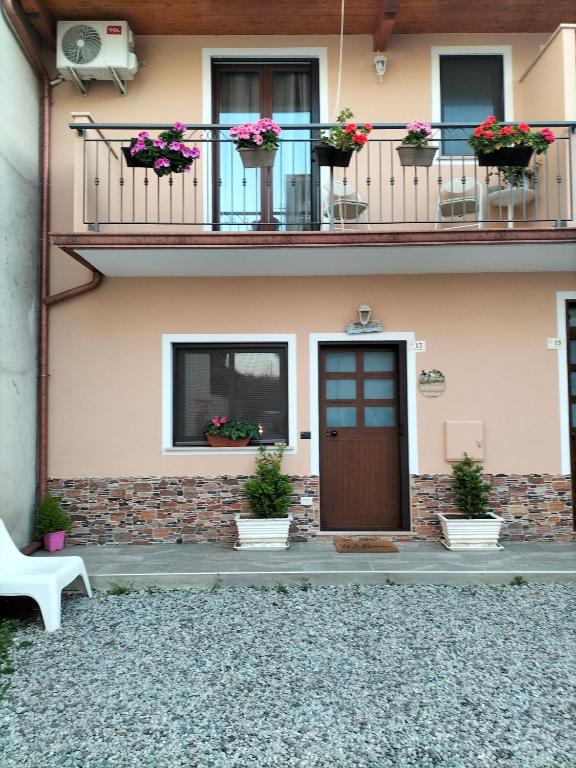 ein Haus mit einem Balkon mit Topfpflanzen und einer Tür in der Unterkunft Borghetto Verde in Locri
