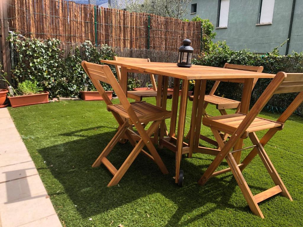 a wooden picnic table and chairs in a yard at Casa adosada familiar con jardín y piscina in Villanúa