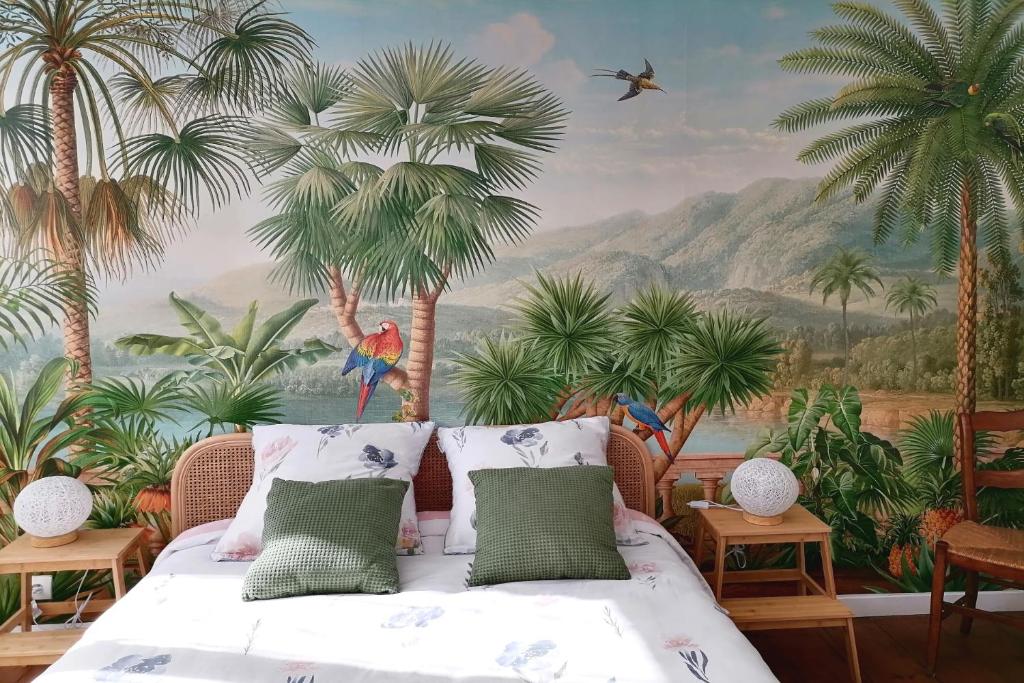 1 dormitorio con un mural de palmeras y 1 cama en Le grand Houx, en Orthez