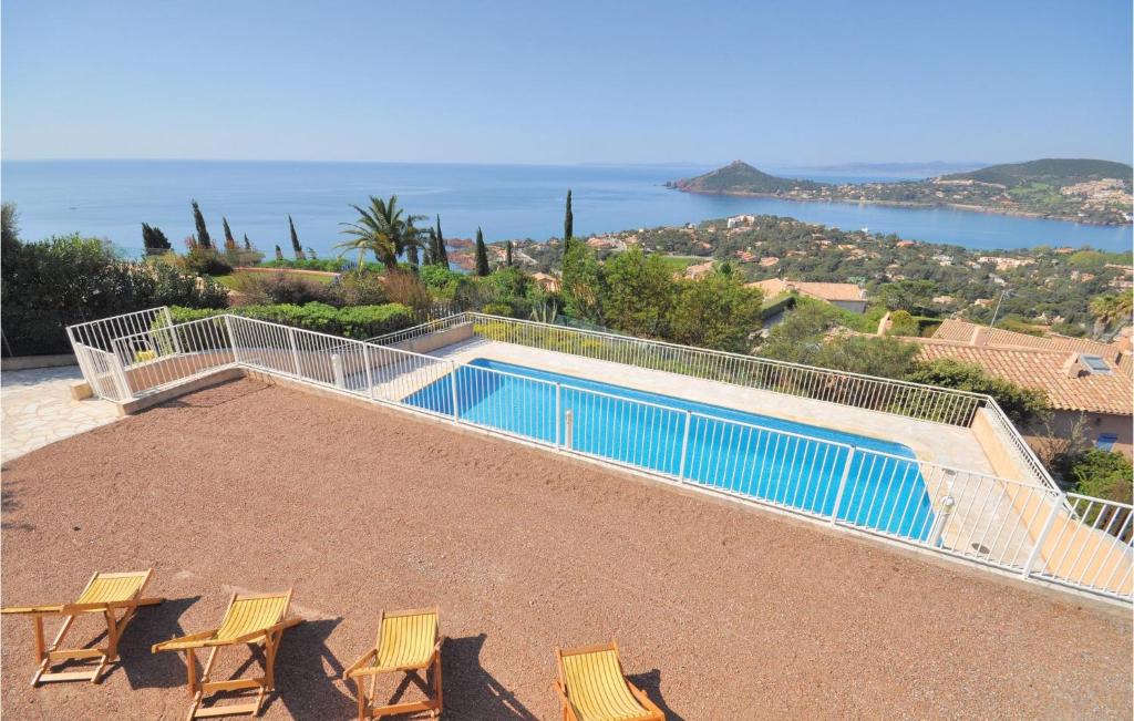 een zwembad met stoelen en uitzicht op de oceaan bij Domaine De La Bastide Dagay in Anthéor