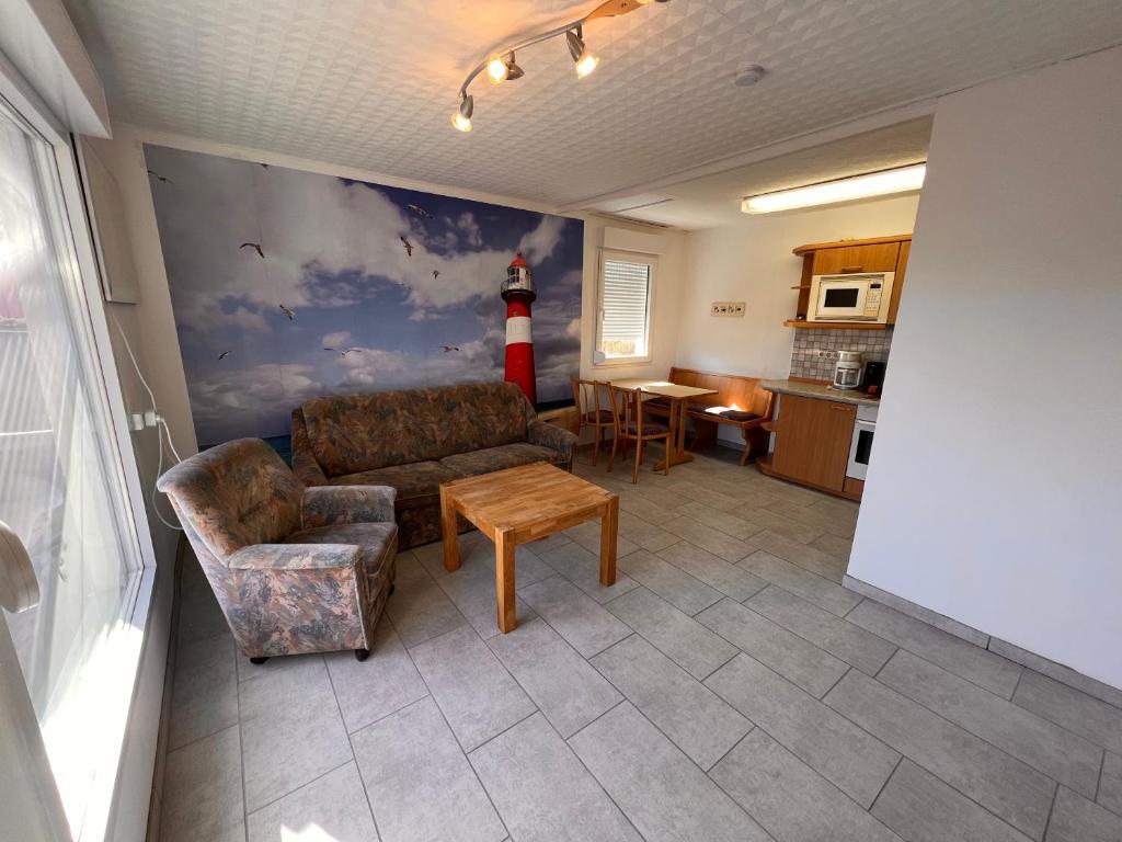 ein Wohnzimmer mit einem Sofa und einem an der Wand gemalten Leuchtturm in der Unterkunft Mona in Graal-Müritz