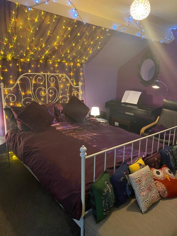 a bedroom with a bed with lights and a piano at Tuebrook Towers in Liverpool