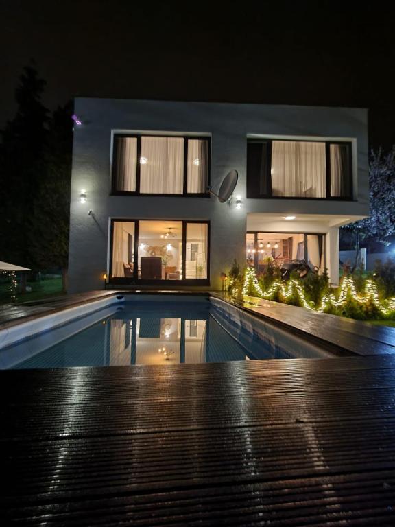 a house with a swimming pool at night at La bella vue in Osenjače